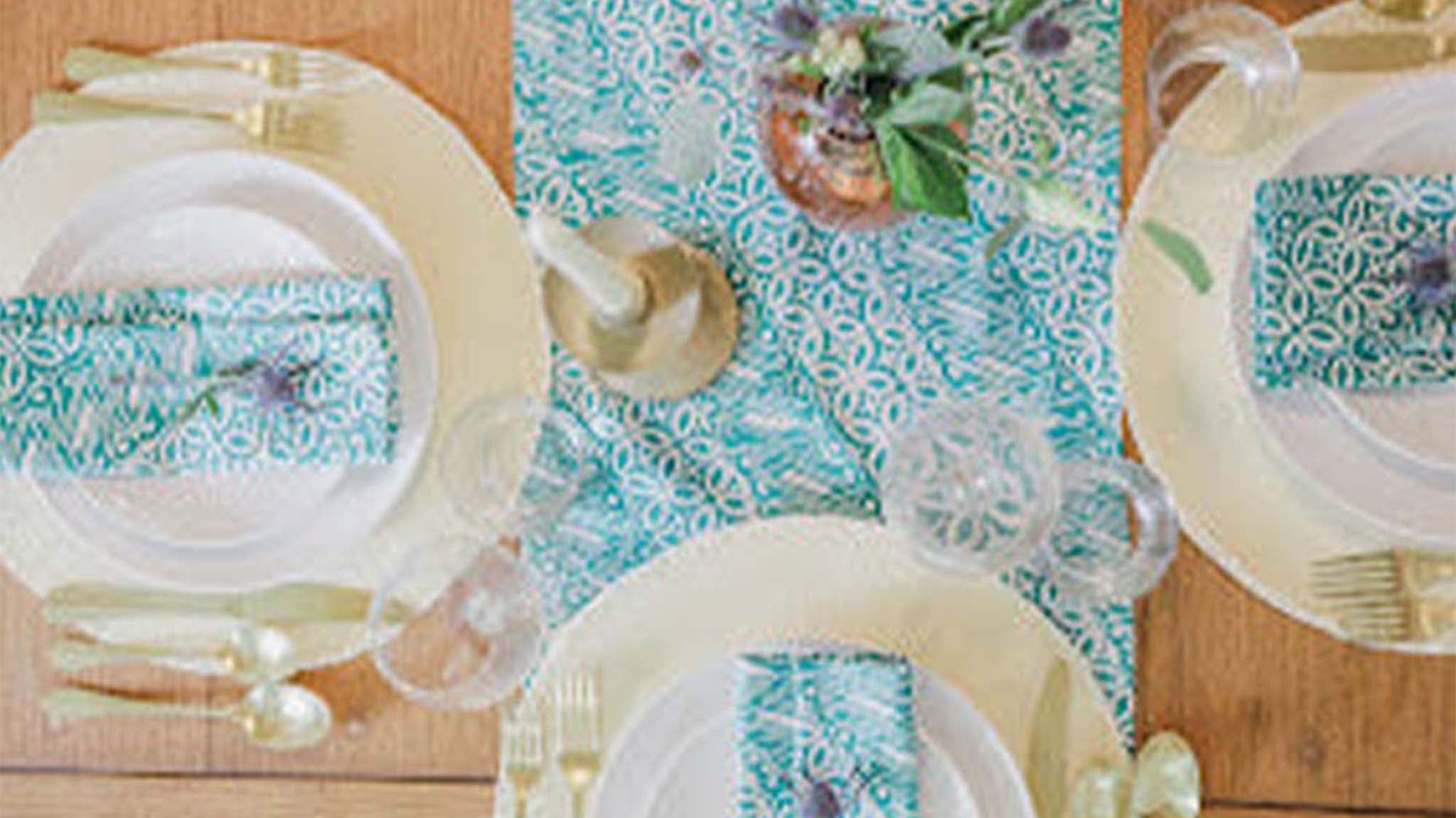 Kasih Co-op batik table runner in Green Royalty pattern styled on a dining table