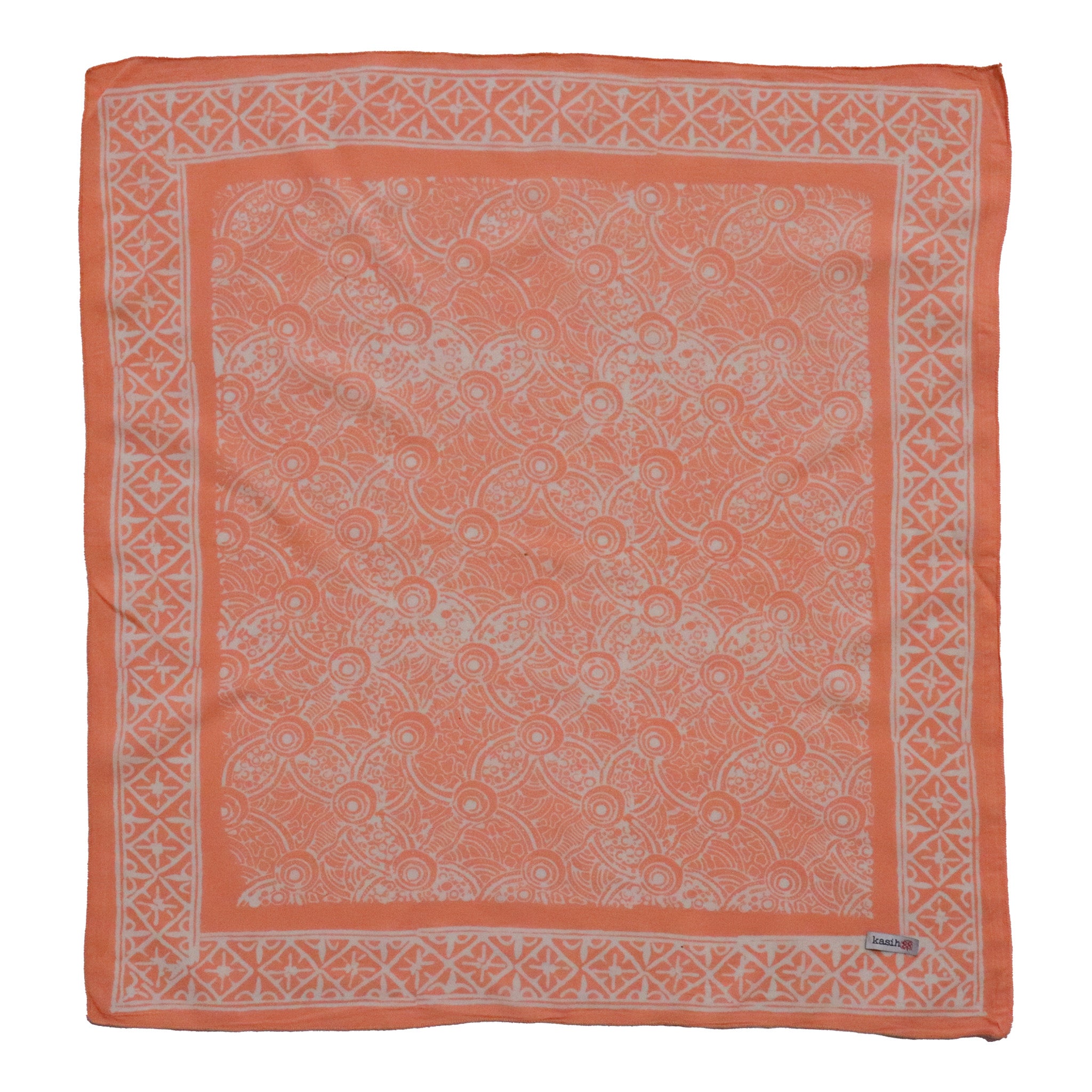 Coral bandana with white geometric pattern on a white background