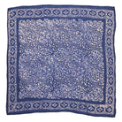 A blue stone hand-dyed and hand-stamped batik bandana with a floral and geometric pattern.