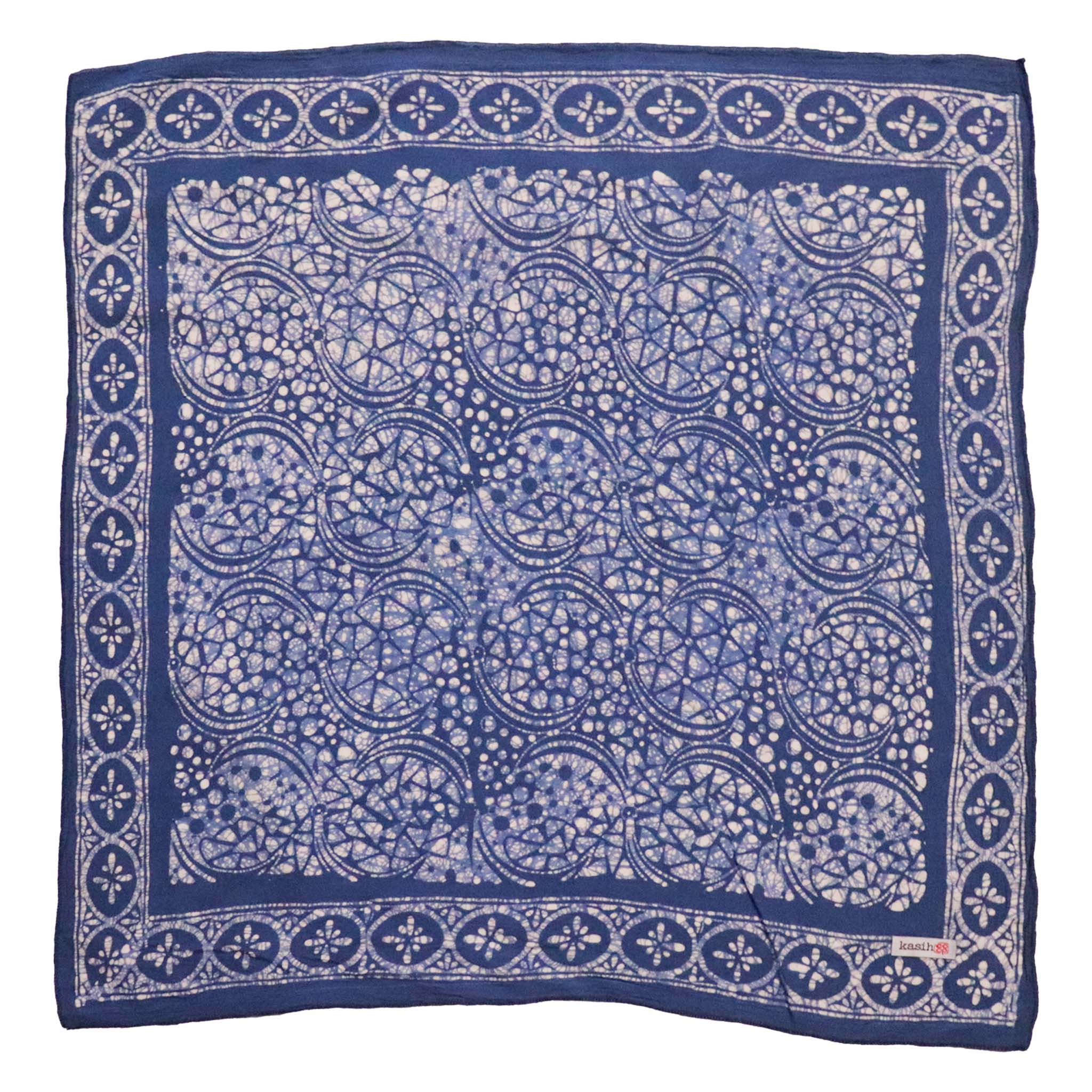 A blue stone hand-dyed and hand-stamped batik bandana with a floral and geometric pattern.