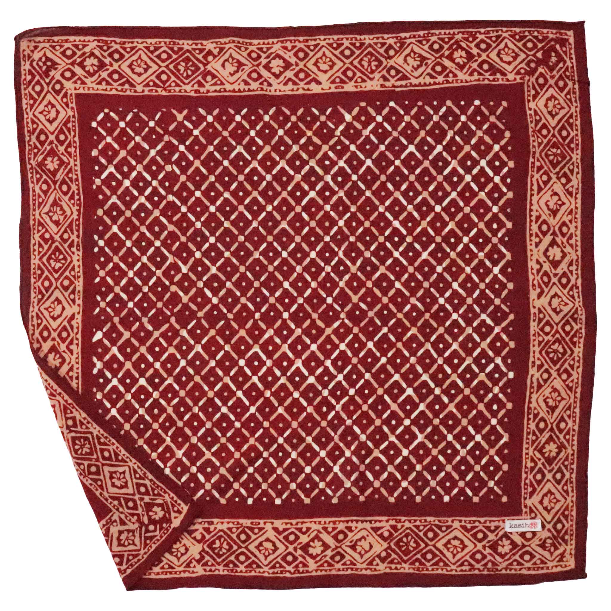 Red and beige patterned cotton bandana on a white background