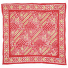 Pink batik bandana with gold and white pattern on a white background
