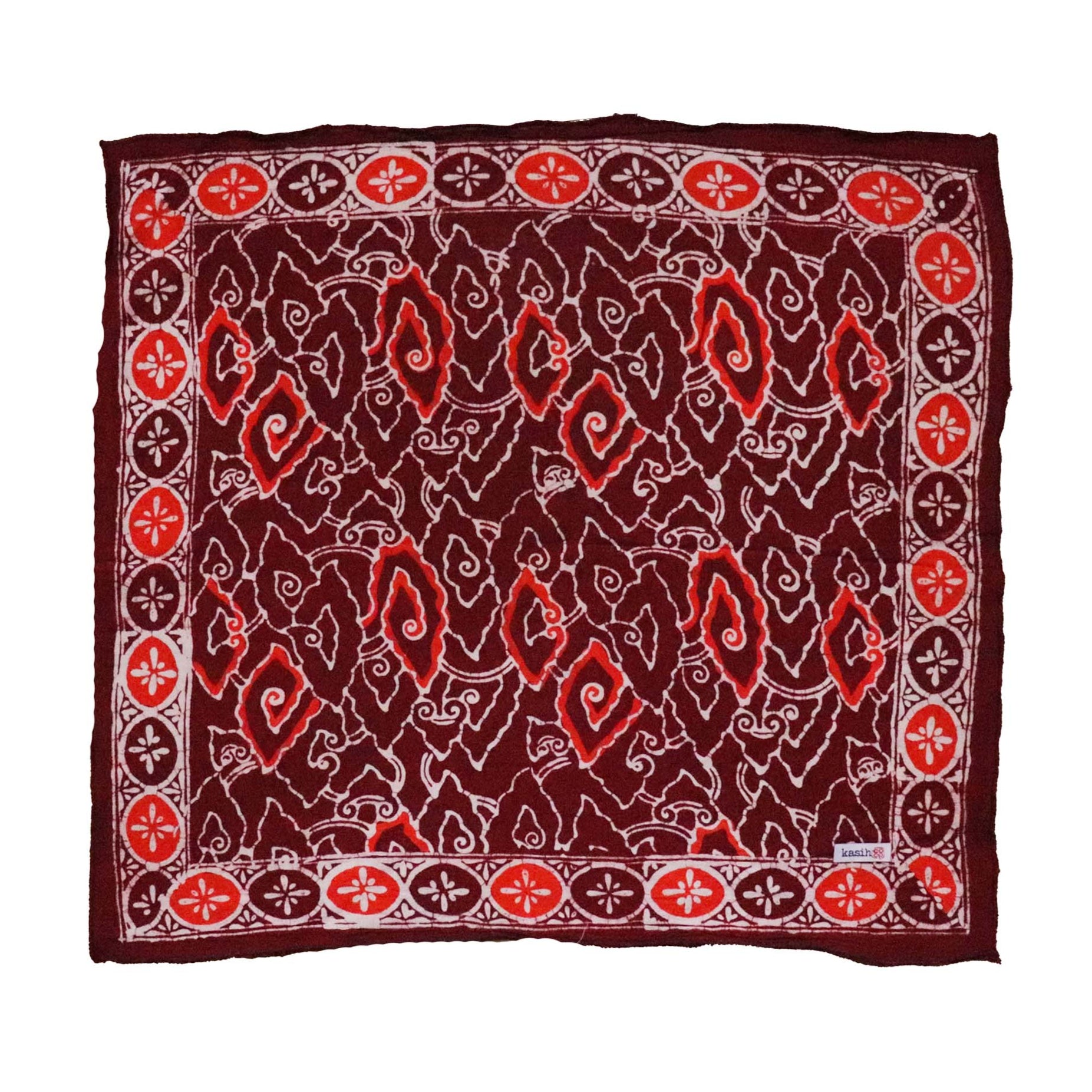 A large hand-dyed batik bandana in shades of red and orange with geometric patterns, displayed flat.