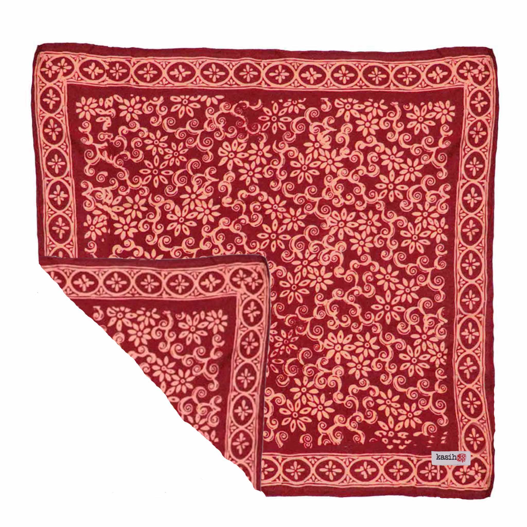 Red patterned batik cotton bandana with white floral designs on a white background