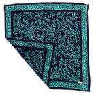 Teal and black patterned batik bandana on a white background