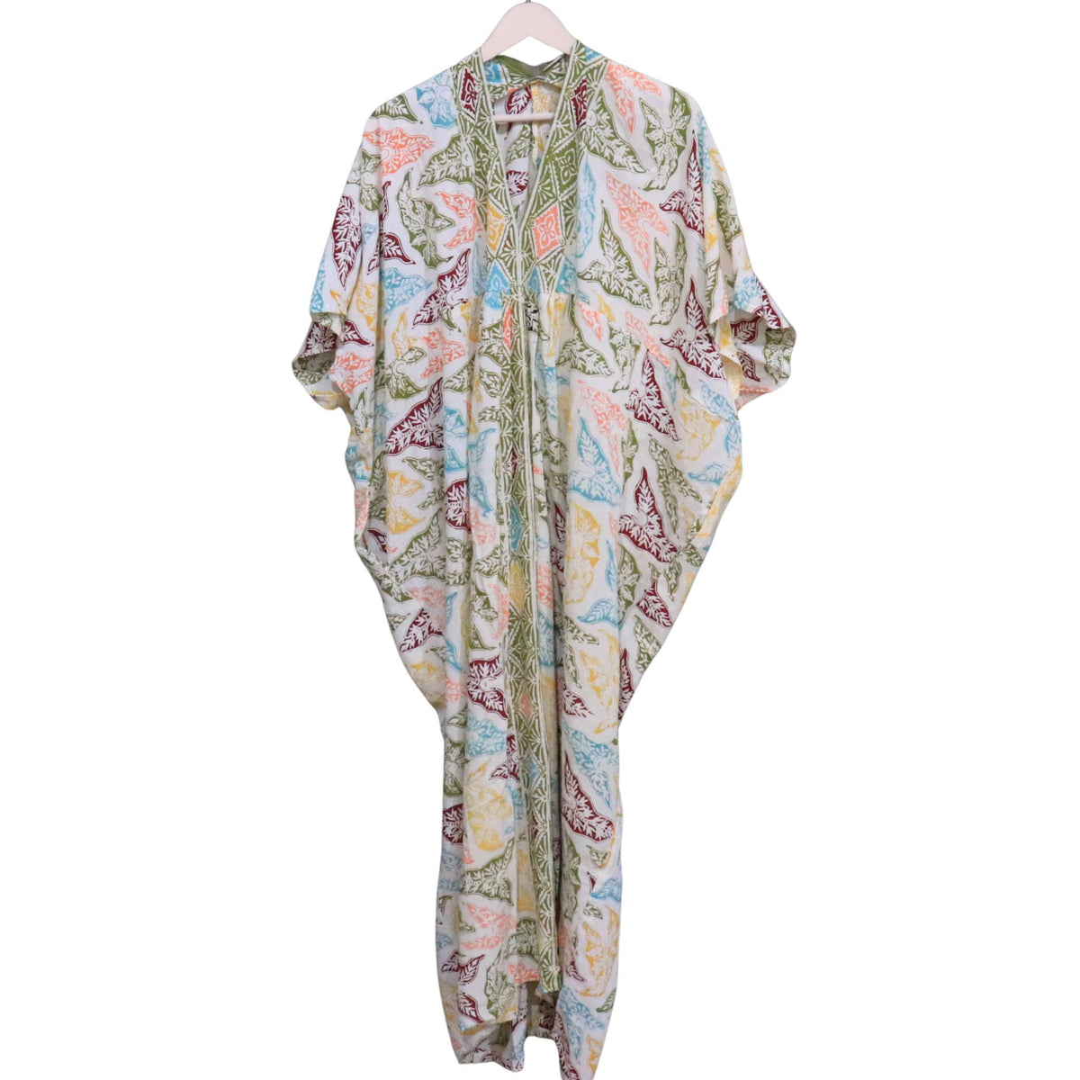 A lightweight, loose-fitting kaftan dress with a colorful paisley pattern, hanging on a wooden hanger against a plain white background.