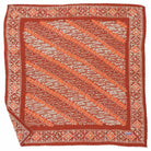 Decorative orange and beige patterned bandana on a white background