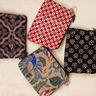 Four patterned batik pouches on a light background